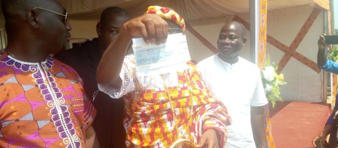 Le maire de Jacqueville, brandissant le chèque remis par Abo Jérôme Le maire de Jacqueville, brandissant le chèque remis par Abo Jérôme