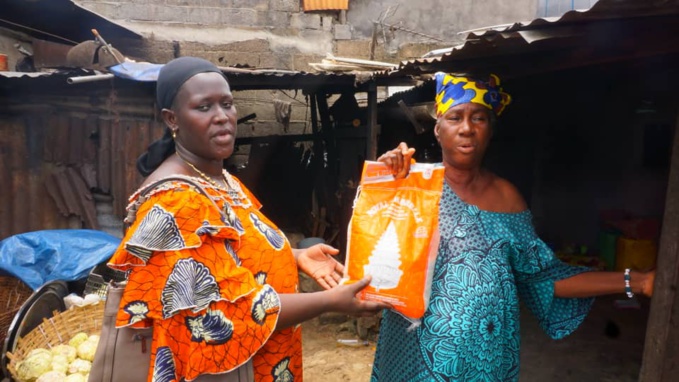 Mme Touré Bintou de l'Ong Pensons le Vivre ensemble remettant un lot de vivre à une bénéficiaire