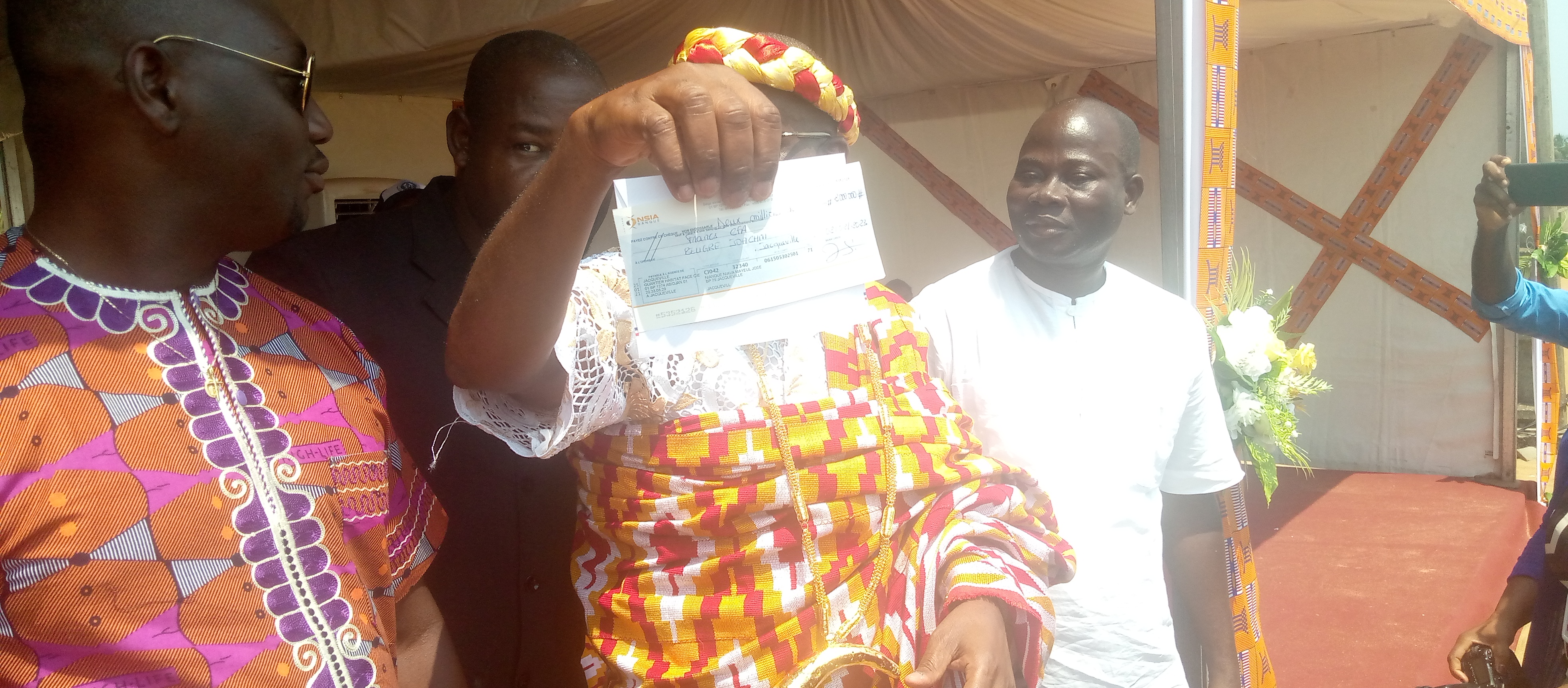 Le maire de Jacqueville, brandissant le chèque remis par Abo Jérôme Le maire de Jacqueville, brandissant le chèque remis par Abo Jérôme